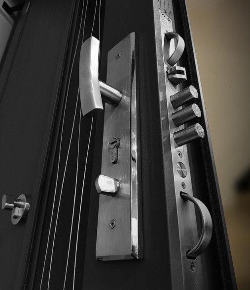 Fourteen stainless steel lock bolts along the edge of an aluminium security door